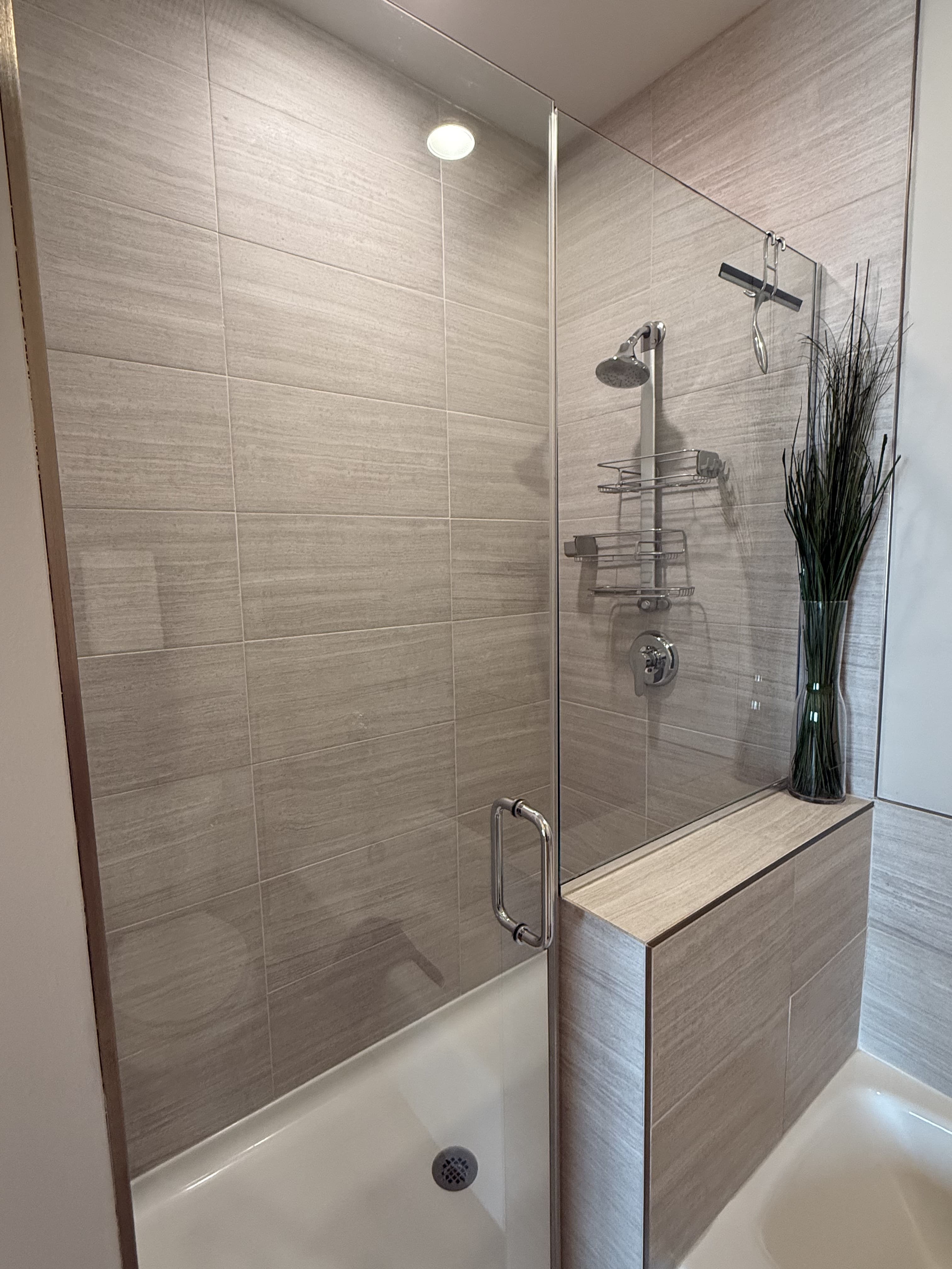 Glass shower and stone tile bathroom after professional deep cleaning in Romeoville IL