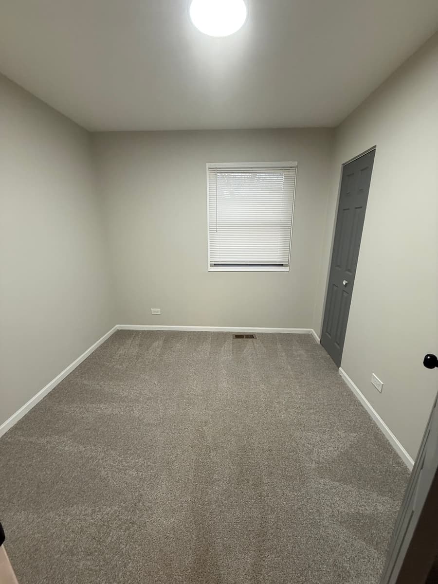 Empty bedroom with fresh vacuum lines fanning out across the carpet after a DSM Cleaning Solutions move-out clean