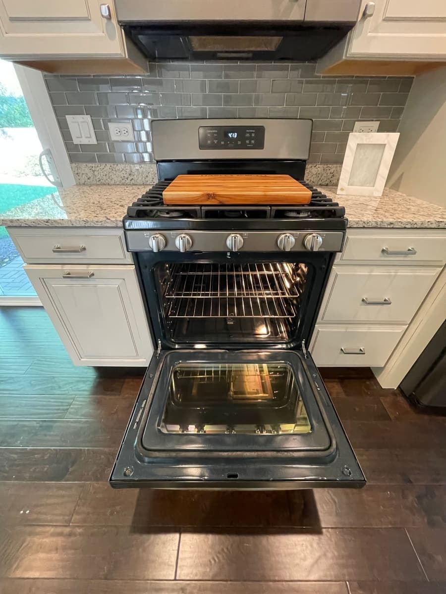 Oven door open showing a spotless interior cavity and racks after a DSM Cleaning Solutions move-out clean