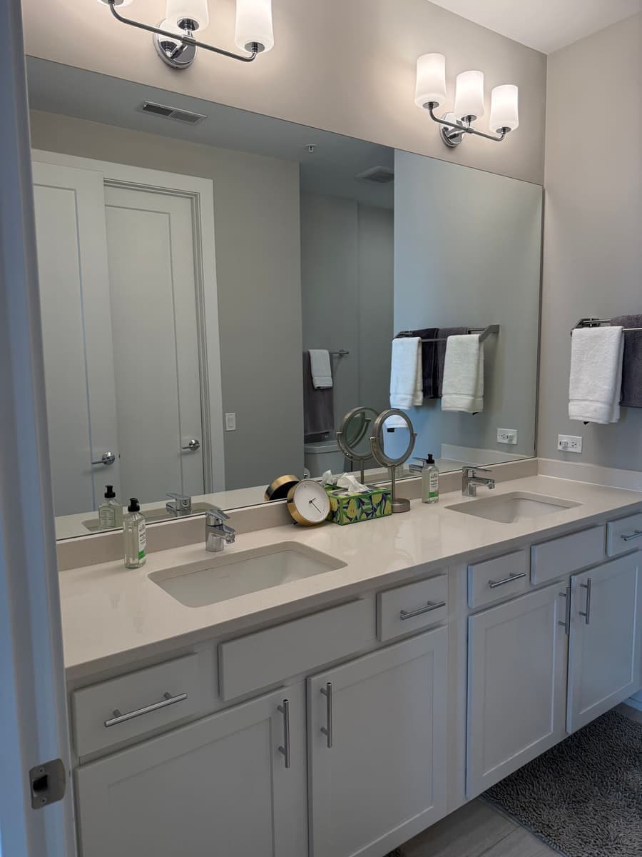 Bathroom double vanity with a tidy countertop and fresh towels after standard house cleaning