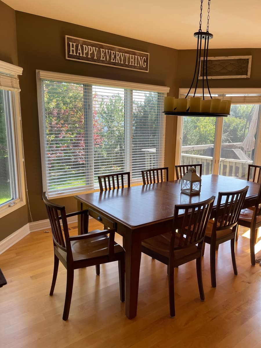 Furnished dining room with a set table and bright natural light after standard house cleaning