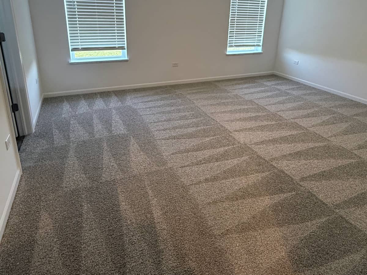 Empty bedroom with fresh vacuum lines in the carpet after a DSM Cleaning Solutions move-out cleaning